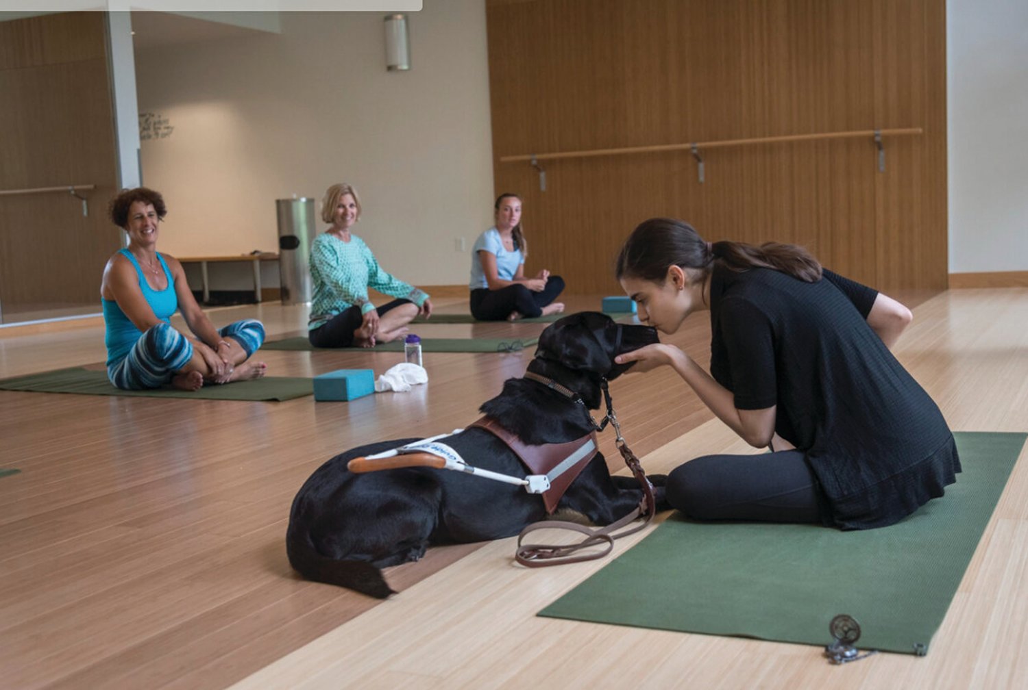 PEACE OF MIND: Aria conducts at a yoga class at URI in 2017 with her guide dog, Ingrid, at her side.